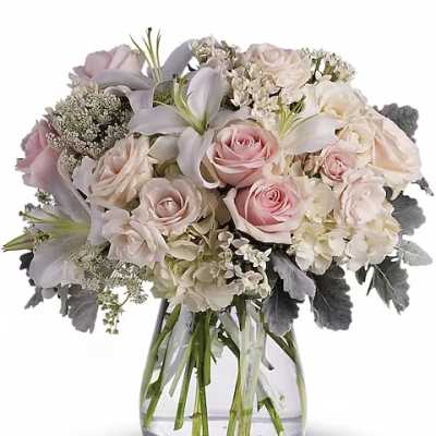 Blush and white bouquet of roses and lilies in a clear glass vase