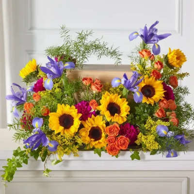 Bright mixed bouquet with sunflowers, purple irises, and orange roses