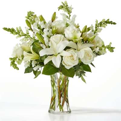 White lilies and roses in a clear glass vase