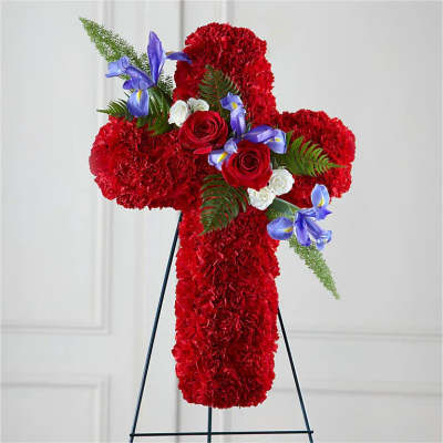 Red floral cross on a black stand with blue and white accents