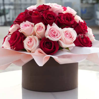 Bouquet of red and pale pink roses in a round box