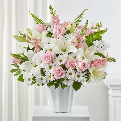 Pink roses and white lilies in a white vase