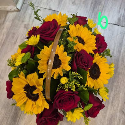 Basket of red roses and yellow sunflowers on a floor.