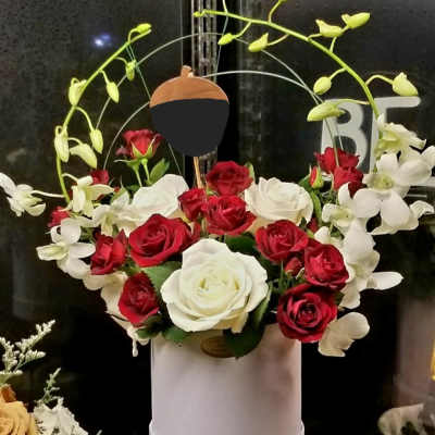 Red and white roses in a white hatbox with arching white orchids