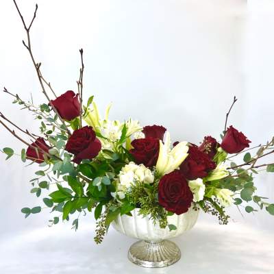 Red roses and white lilies in a white pedestal vase