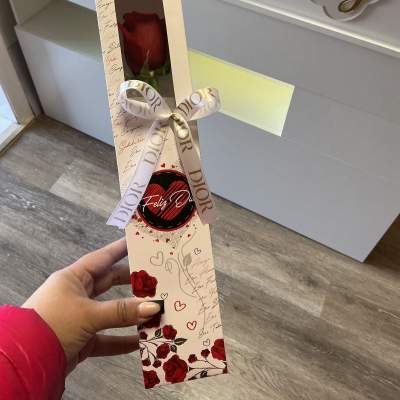Single red rose in a decorative gift box with a ribbon