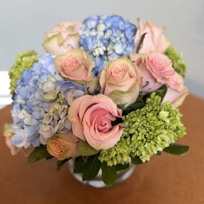 Bouquet of pink roses and blue hydrangeas in a vase