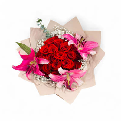 Wrapped bouquet of red roses with pink lilies and white baby's breath