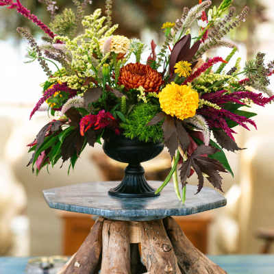 Colorful floral arrangement in a black pedestal vase