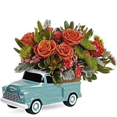 Orange roses arranged in a turquoise pickup truck container