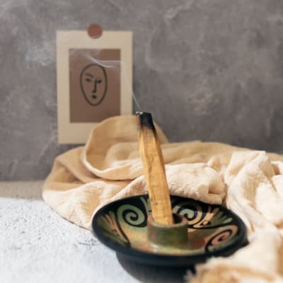 Burning incense in a decorative bowl with a small card behind it