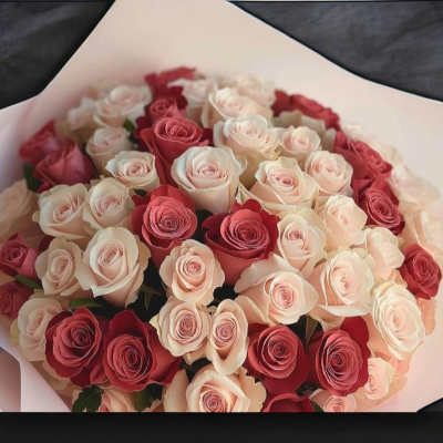 Bouquet of red, blush, and white roses wrapped in pale paper