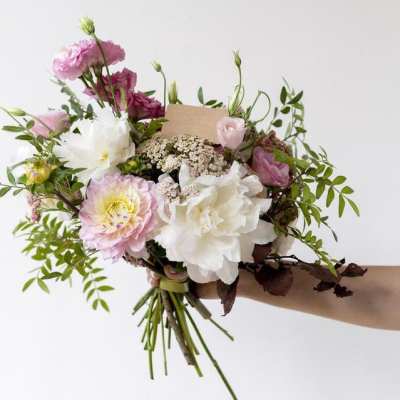 Handheld bouquet of pink and white flowers with airy greenery