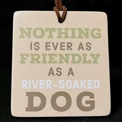 Square hanging sign with the text "Nothing is ever as friendly as a river-soaked dog"