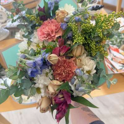 Hand-tied bouquet of mixed flowers in pink, white, and blue