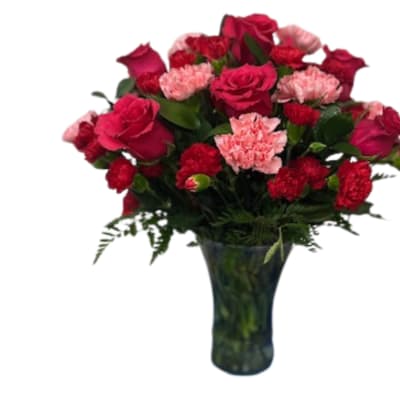 Bouquet of red roses and pink carnations in a dark glass vase