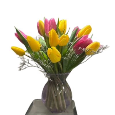 Bouquet of yellow and pink tulips in a glass vase