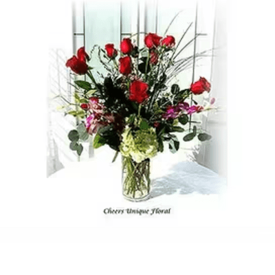 Red roses and mixed flowers arranged in a clear glass vase