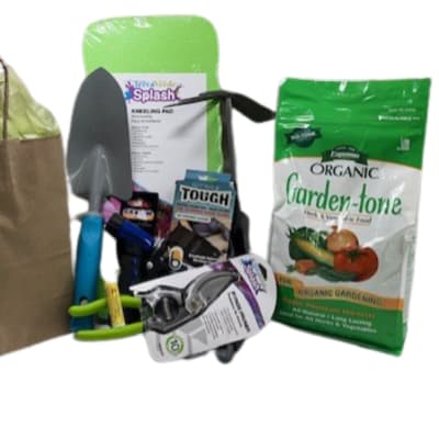 Garden gift set with a paper bag, trowel, gloves, and seed packets