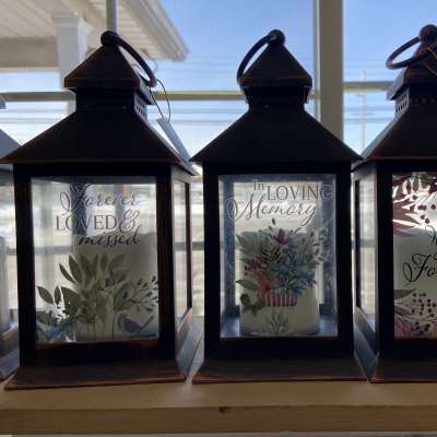 Three memorial lanterns with sentimental text and floral designs