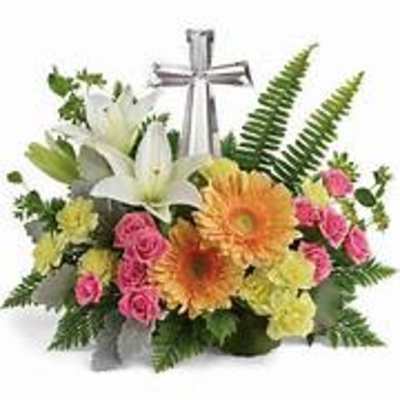 Mixed flower arrangement with lilies, gerberas, and pink roses around a silver cross