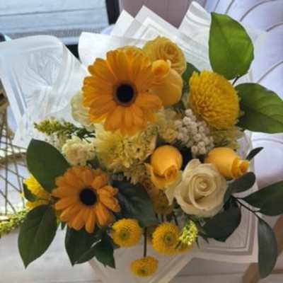 Bouquet of orange and yellow flowers with white wrapping paper