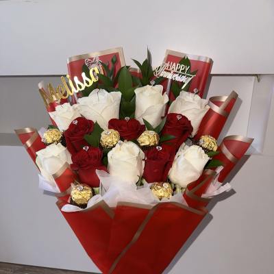 Bouquet of red and white roses with chocolates in red wrapping