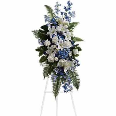 White and blue funeral spray on a standing easel