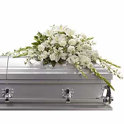 White floral casket spray on a gray casket