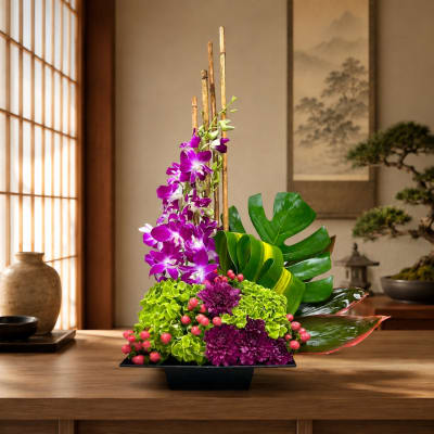 Purple orchids and green hydrangeas arranged in a black vase