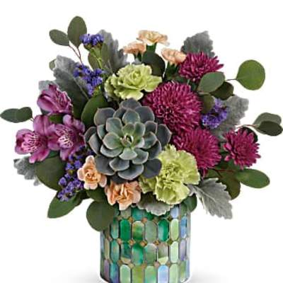Compact arrangement with succulent, purple mums, green carnations in a mosaic cylinder vase