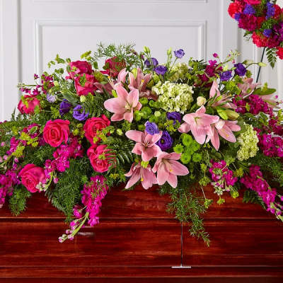 Large pink and purple floral casket spray with lilies and roses