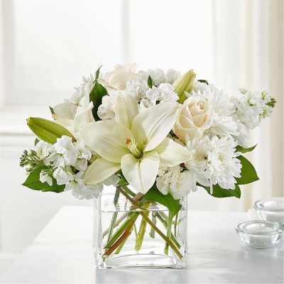 White lilies and roses in a clear glass vase