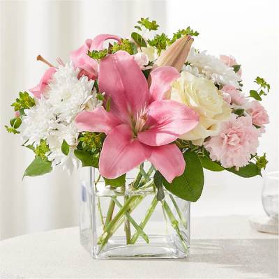 Pink lilies and white flowers in a clear glass vase