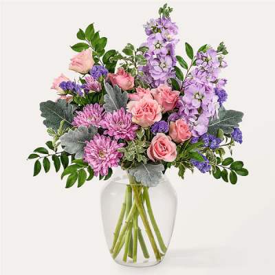 Pink and lavender flowers arranged in a clear glass vase