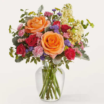 Bouquet of orange and red roses in a clear glass vase