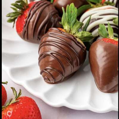 Chocolate-covered strawberries on a white serving plate
