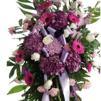 Tall purple and pink floral standing spray with ribbon streamers