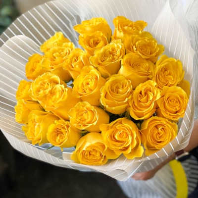 Bouquet of yellow roses wrapped in white paper