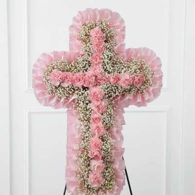 Pink floral cross-shaped standing spray with carnations and baby's breath