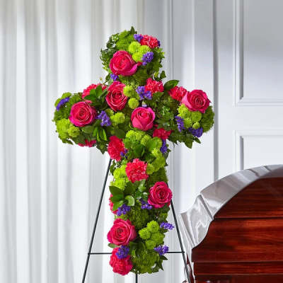 Cross-shaped floral spray with pink roses and bright green and purple flowers