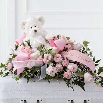 Pink rose arrangement with a teddy bear and ribbon accents