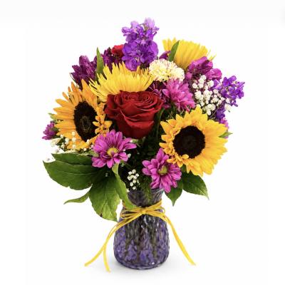 Bouquet of sunflowers, roses, and purple flowers in a purple vase