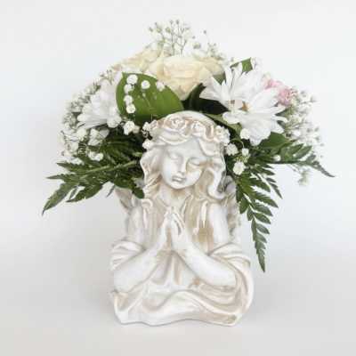 White floral arrangement in a decorative angel planter
