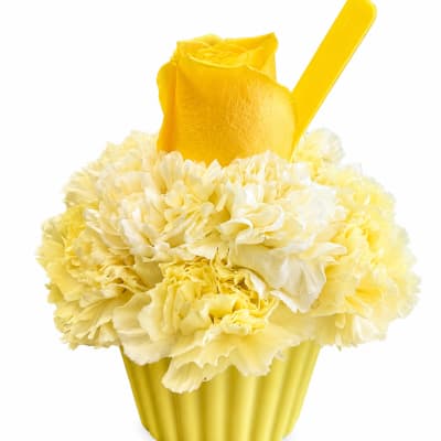 Yellow carnations in a yellow cup with a spoon