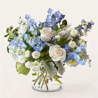 Blue and white flower arrangement in a clear glass vase