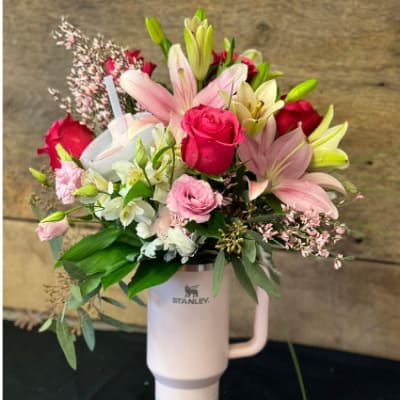 Bouquet of pink roses and lilies in a Stanley tumbler