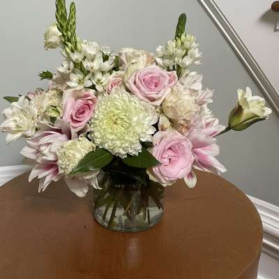 Pink and white mixed flower arrangement in a glass vase