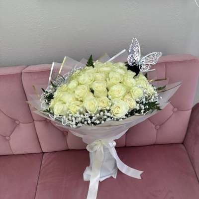 Bouquet of pale yellow roses with butterfly picks and a white ribbon wrap