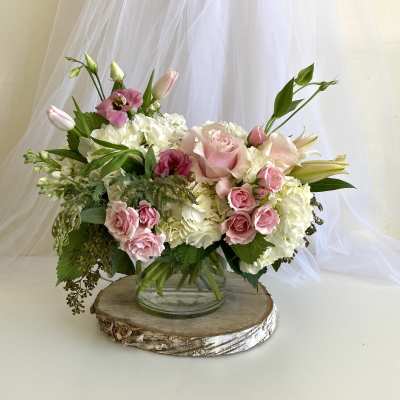 Pink and white floral arrangement in a clear glass vase